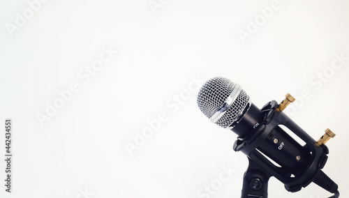 small microphone with a stand on a white background. place for your text. sound and voice concept.