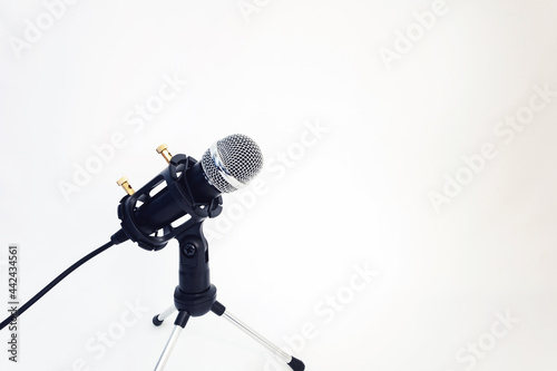 small microphone with a stand on a white background. place for your text. sound and voice concept.