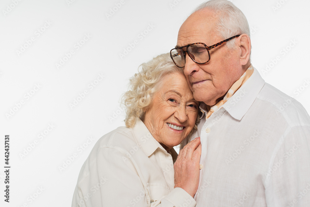 elderly woman gently hugging senior man with hand on breast isolated on white elderly woman gently hugging senior man with hand on breast isolated on white