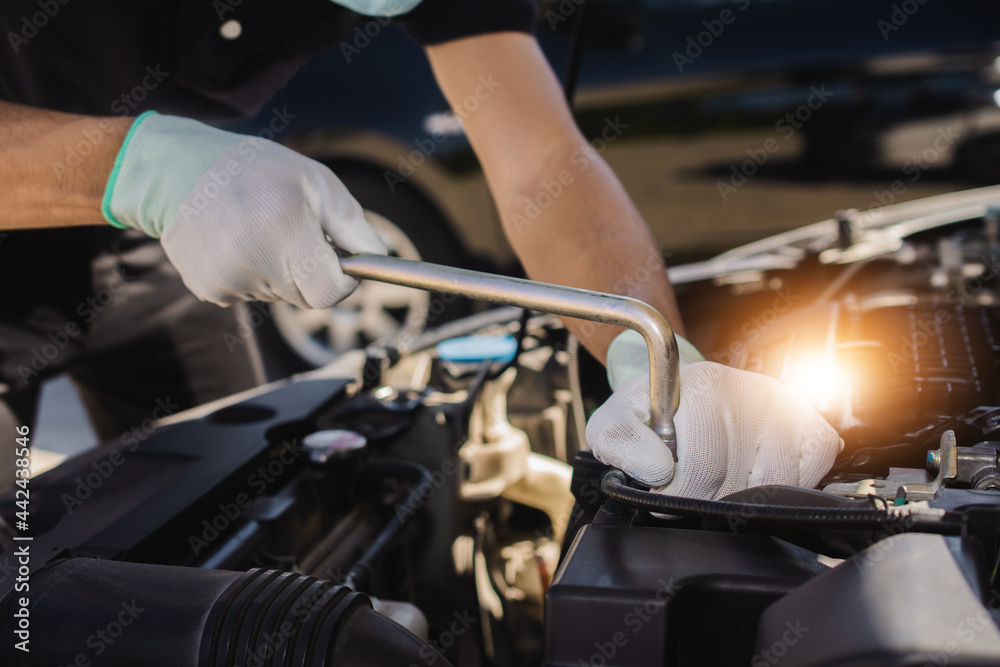Repairman mechanic fixing a car with a socket wrench