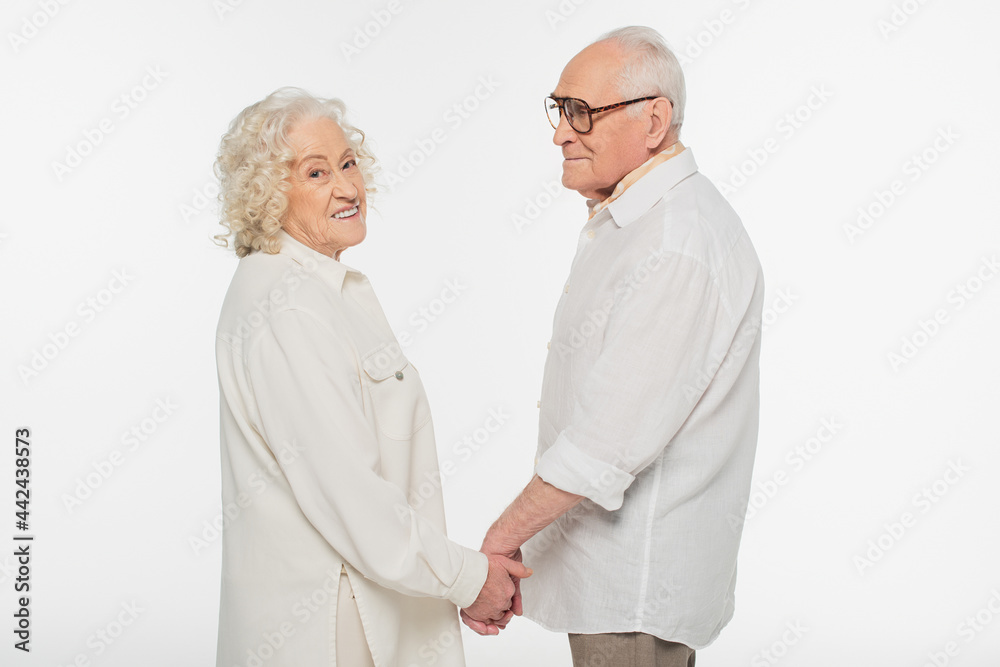 happy elderly couple in casual clothes standing with holding hands isolated on white happy elderly couple in casual clothes standing with holding hands isolated on white