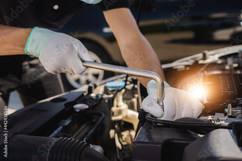 Repairman mechanic fixing a car with a socket wrench © Suriyo