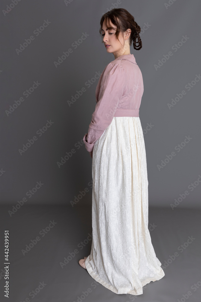 A young Regency woman wearing a cream embroidered dress and pink linen spencer A young Regency woman wearing a cream embroidered dress and pink linen spencer