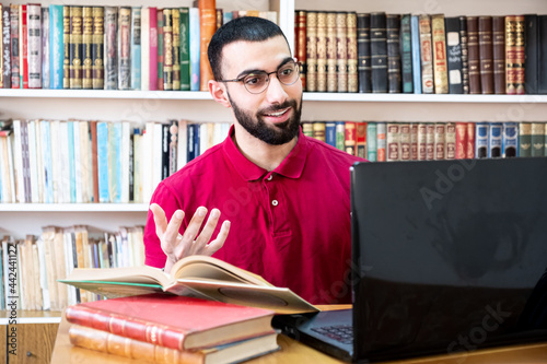 Arabic man using a laptop during conferences or meetings for studying and teaching through online channels