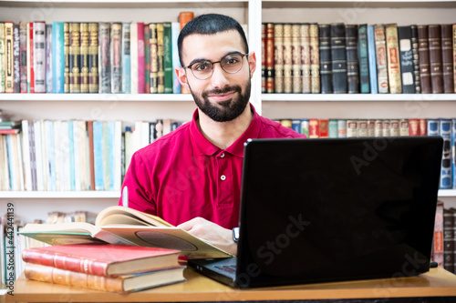 Arabic man using a laptop during conferences or meetings for studying and teaching through online channels