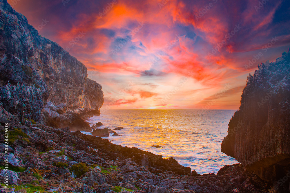 sunrise captured at the bluff in Cayman Brac in the Cayman Islands. The light from the sun has lit the rocky cliff face as well as the clouds above