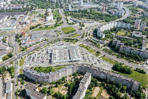 panoramic aerial view of modern residential neighborhood, road intersection, shopping malls and parking lots in city of Minsk, Belarus