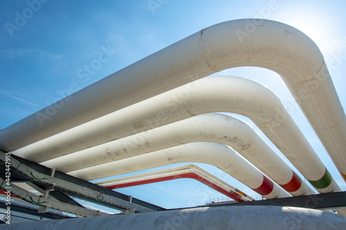Oil pipeline and Oil storage tank farm in the petroleum refinery.Above ground storage tanks can be used to hold materials such as petroleum,waste matter, water,chemicals,and other hazardous materials.