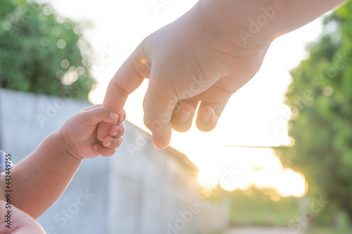 Close up baby holding mother's hand. Happy family concept. The touching and lovely moment.