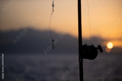 Sea fishing reel during sunrise. Fishing rods for big fich.
