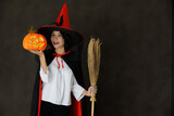 Happy witch with pumpkin and broom