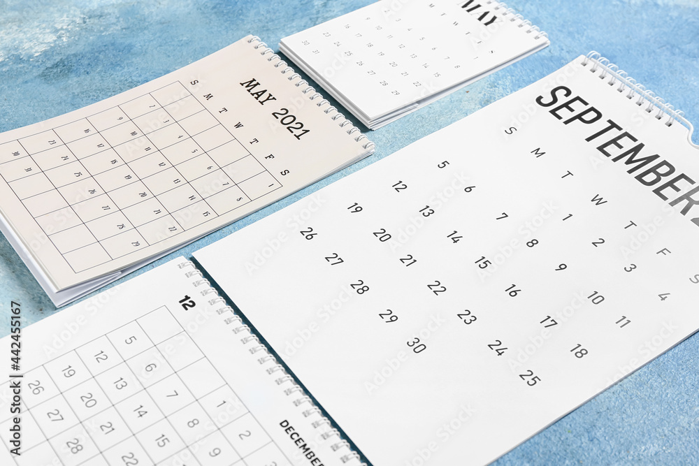Flip paper calendars on color background, closeup Flip paper calendars on color background, closeup