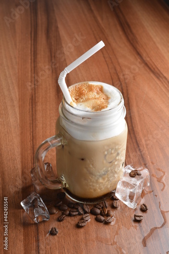 ice cafe mocha latte drink with bubbles and coffee bean in glass on wood table coffee beverage menu photo
