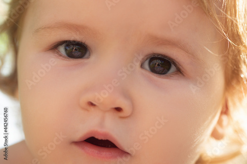 Close up portrait of a small blond baby boy  cropped face. Funny kids face.