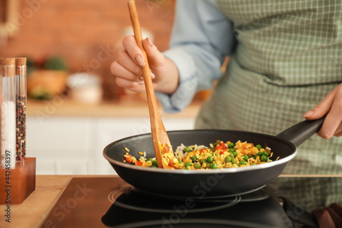 Woman cooking tasty rice wi...
