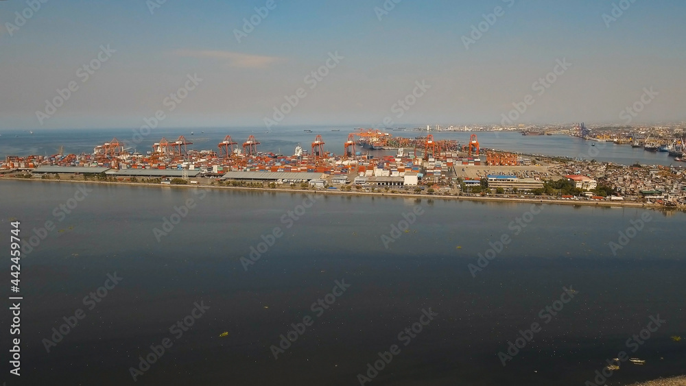 Aerial view industrial cargo port with ships and cranes, Manila. View of the cargo port and container terminal. Container cranes in Manila Bay. Cargo ship in industrial port, Philippines.