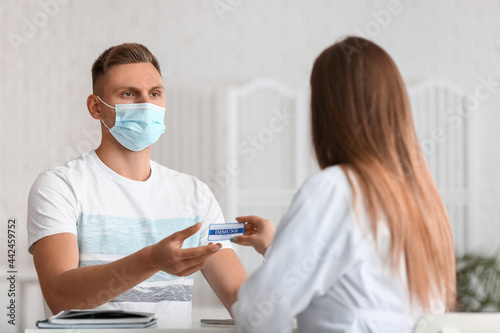 Doctor giving patient his immune card in clinic