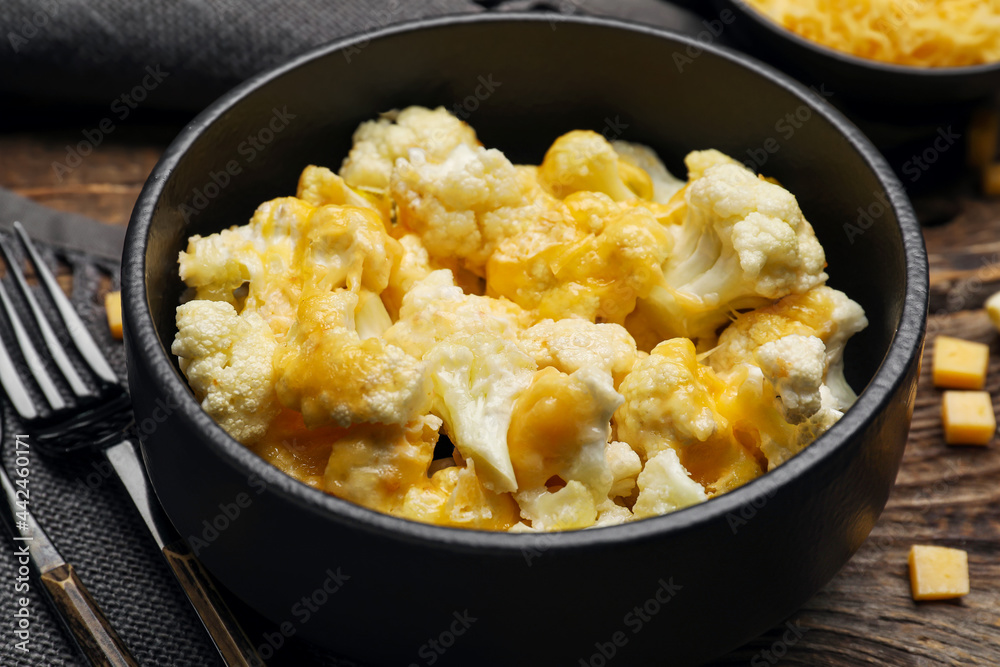 Bowl with tasty cauliflower and cheese on wooden background, closeup Bowl with tasty cauliflower and cheese on wooden background, closeup