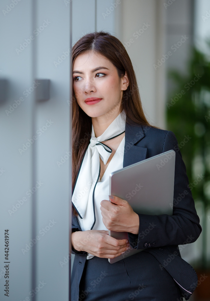 Happy businesswoman with laptop in office building Happy businesswoman with laptop in office building
