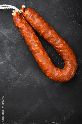 Traditional chorizo sausages on black surface with copy space