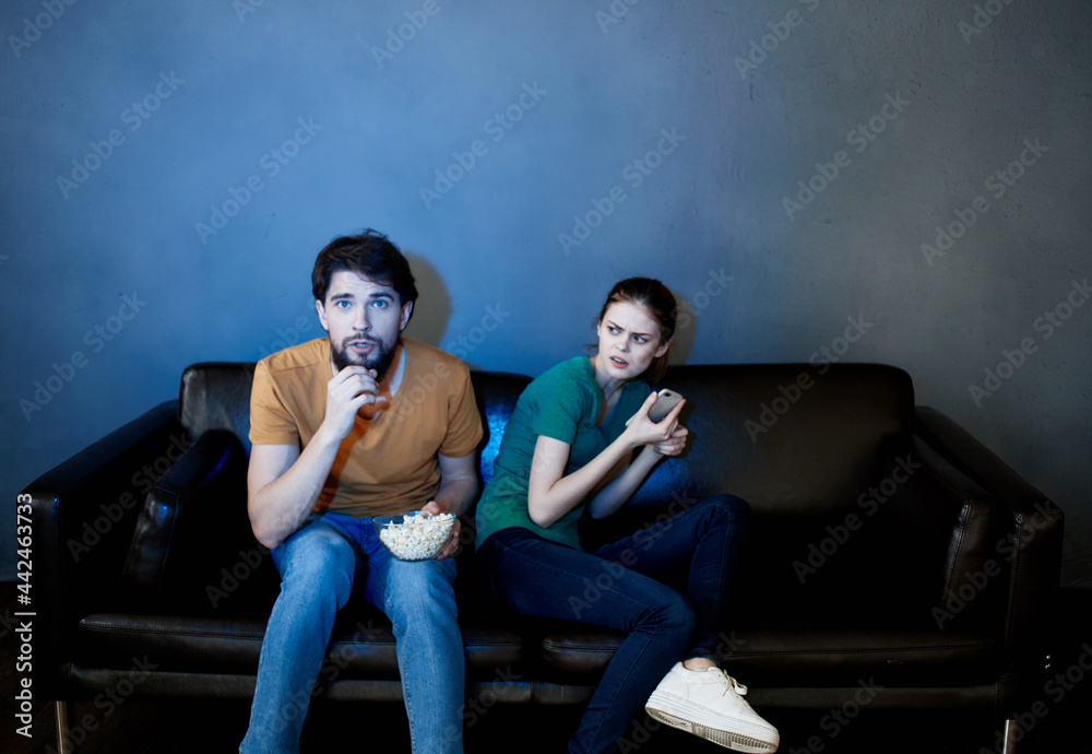 Young family sitting on the couch watching movies popcorn