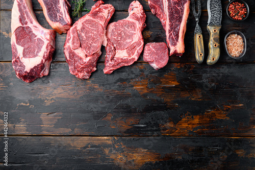 Raw fresh marbled meat Steak, seasonings, tomahawk, t bone, club steak, rib eye and tenderloin cuts, on old dark wooden table background, top view flat lay, with copy space for text