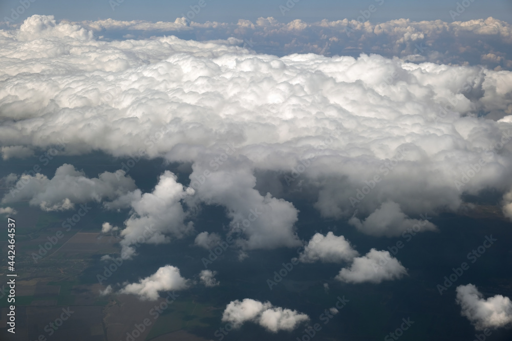 Aerial view from airplane window of white puffy clouds on bright sunny day. Aerial view from airplane window of white puffy clouds on bright sunny day.