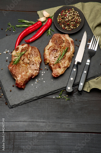 Grilled roated beef steaks on stone serving cutting board