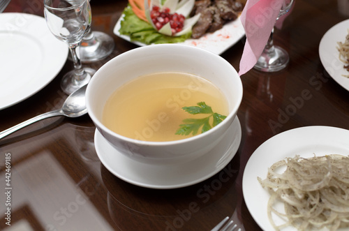 Wallpaper Mural Delicious golden beef broth in a plate with a parsley leaf on the banquet table Torontodigital.ca