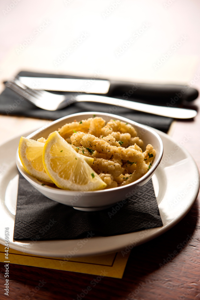 Plate of fried squid and lemon slices Plate of fried squid and lemon slices