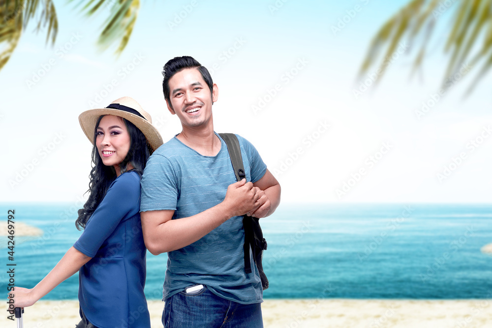 Asian couple with hat and backpack traveling to the beach