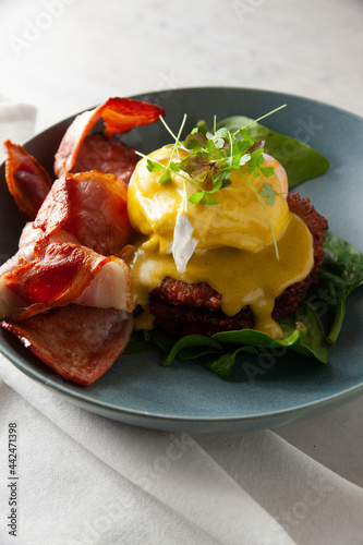 Bacon and eggs benedict on salad photo