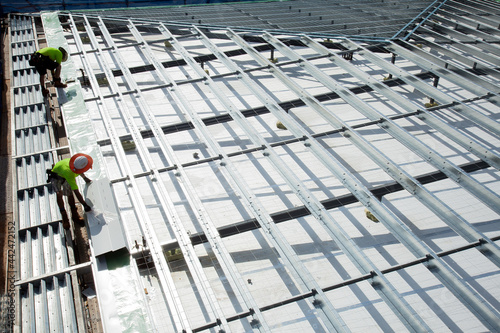 Construction workers with metal framework on an industrial building site photo