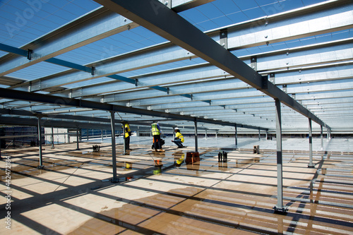 Metal framework and workers on an industrial building site photo