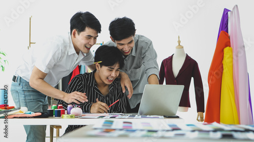 Asian dressmakers using laptop in atelier
