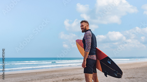 Young man on the seashore with surfboard