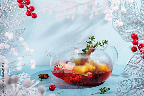 Immunity boosting drink. Winter Tea with cranberries, orange and spices in glass teapot