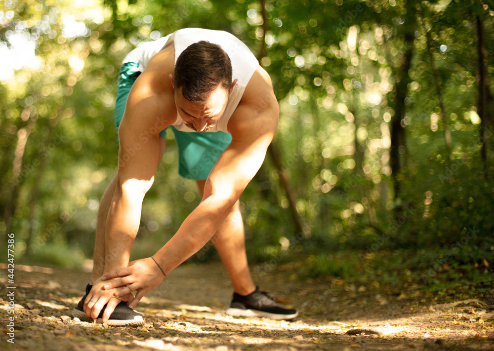 Fototapeta premium Young man making exercises outdoors.