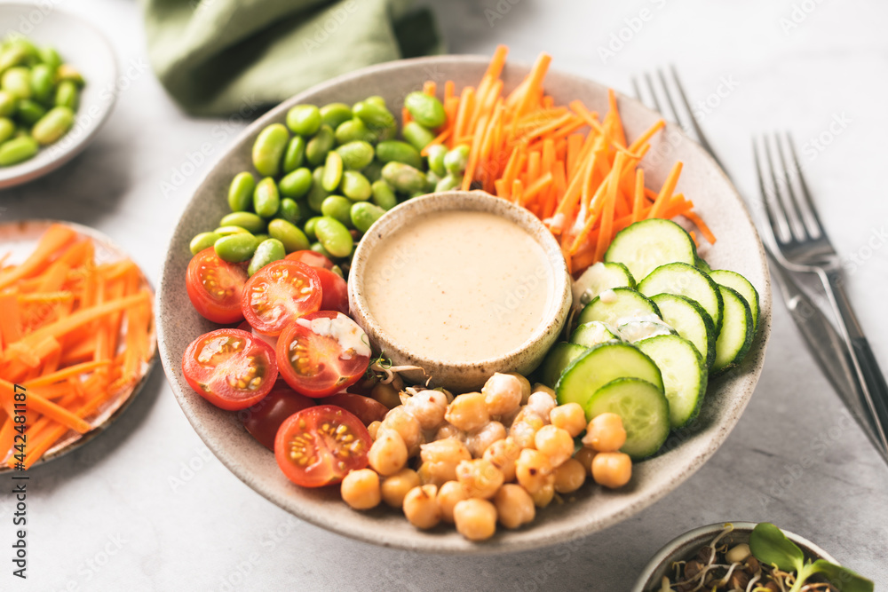 Buddha bowl with cashew sauce, chickpeas, edemame beans and vegetables. Healthy vegan food rich in nutrients and fiber