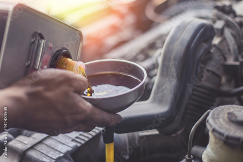 Hand mechanic in repairing car,Change the oil, Refueling and pouring oil quality into the engine motor car Transmission and Maintenance Gear .Energy fuel concept.