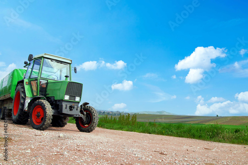 Farming  covered wagon  tractor with trailer moving on the road along vineyards on a sunny day in Rhineland Palatinate  Germany