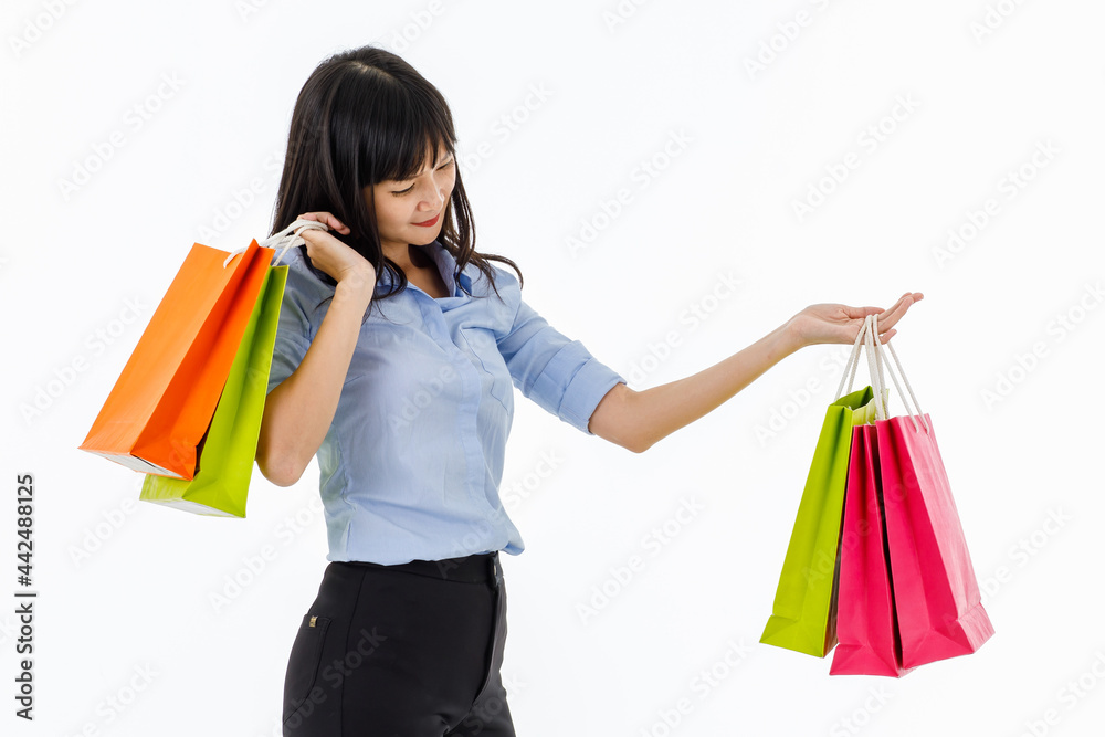 Young lady standing in studio show colorful shopping bags in her hands with big smile seems like she happy to be shopper. Concept buyer, consumerism, discount, lifestyle, sale, discount, shopaholic.