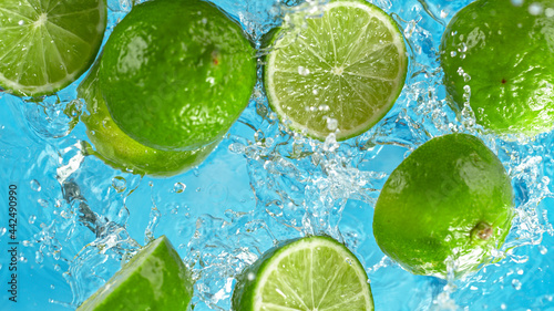 Fresh limes falling into wa...