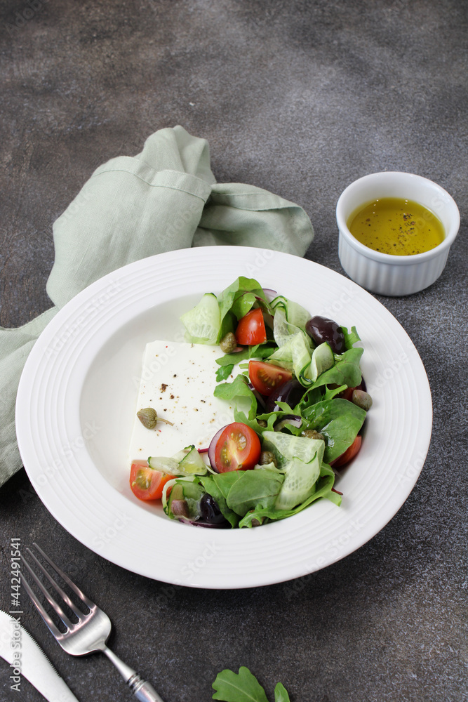 Greek style vegetable salad with cherry tomatoes, feta cheese, red onions, olives, olive oil, lettuce. Mediterranean diet salad recipe, dark photo, copy space Greek style vegetable salad with cherry tomatoes, feta cheese, red onions, olives, olive oil, lettuce. Mediterranean diet salad recipe, dark photo, copy space