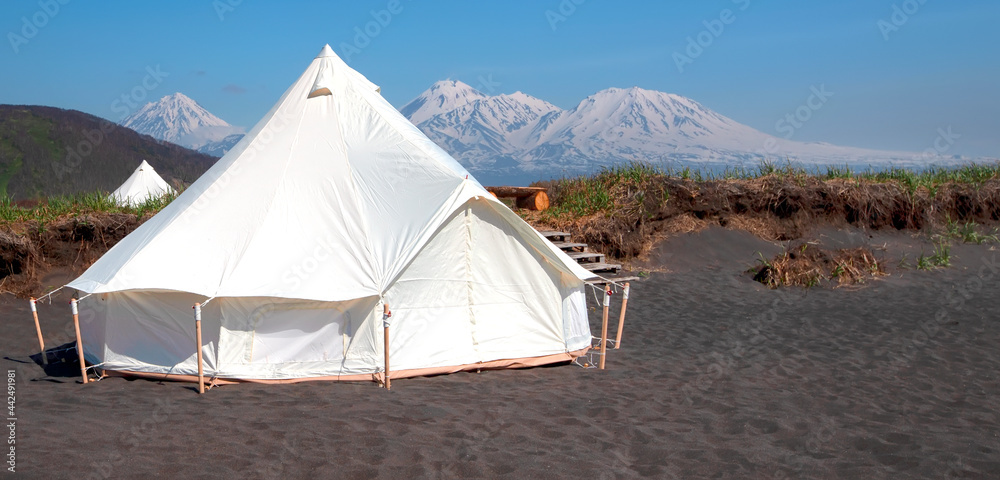 Glamping house in summer and volcano, rural landscape, tent houses in Kamchatka peninsula