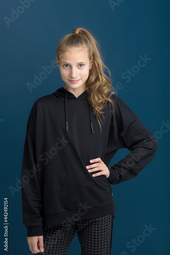 Pretty teenage girl in black hoodie.