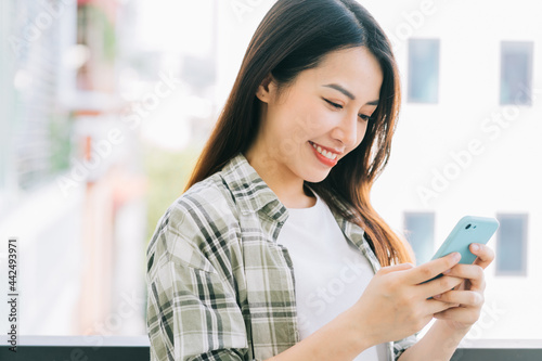 Portrait of young Asian woman using smartphone at home