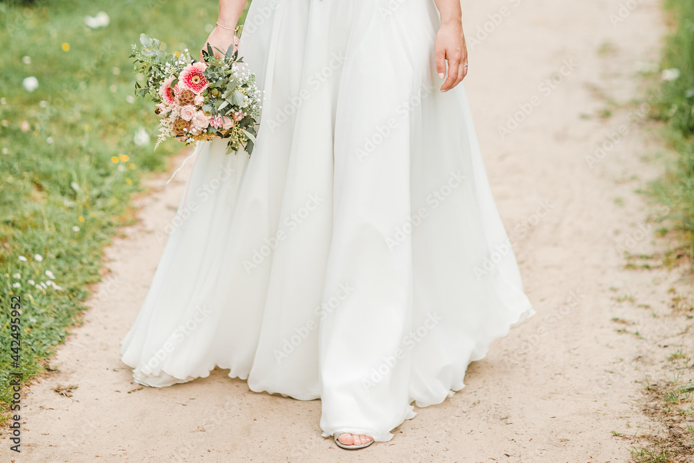 bride holding bouquet. bride is running in a park. Long wedding dress. Concept of wedding, wedding dress and bridal bouquet bride holding bouquet. bride is running in a park. Long wedding dress. Concept of wedding, wedding dress and bridal bouquet