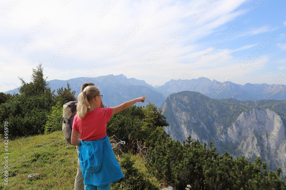 Zwei Wanderer genießen die schöne Aussicht in den Bergen in den steirischen Alpen. Wandern ist die beste Erholung in den Natur.
