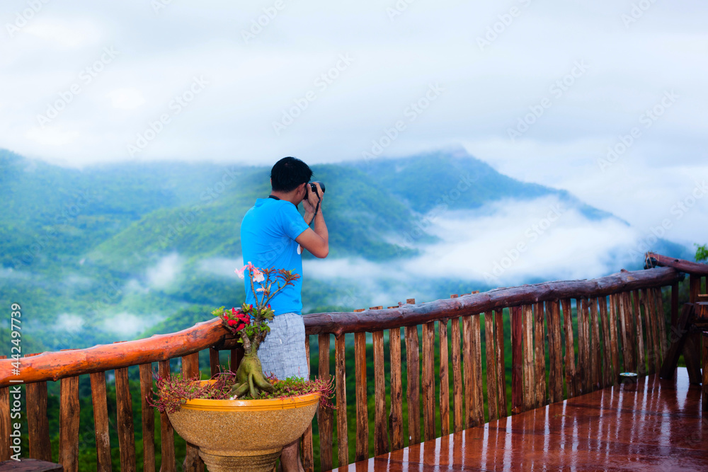 the man taking photo on the top of the mountain in morning